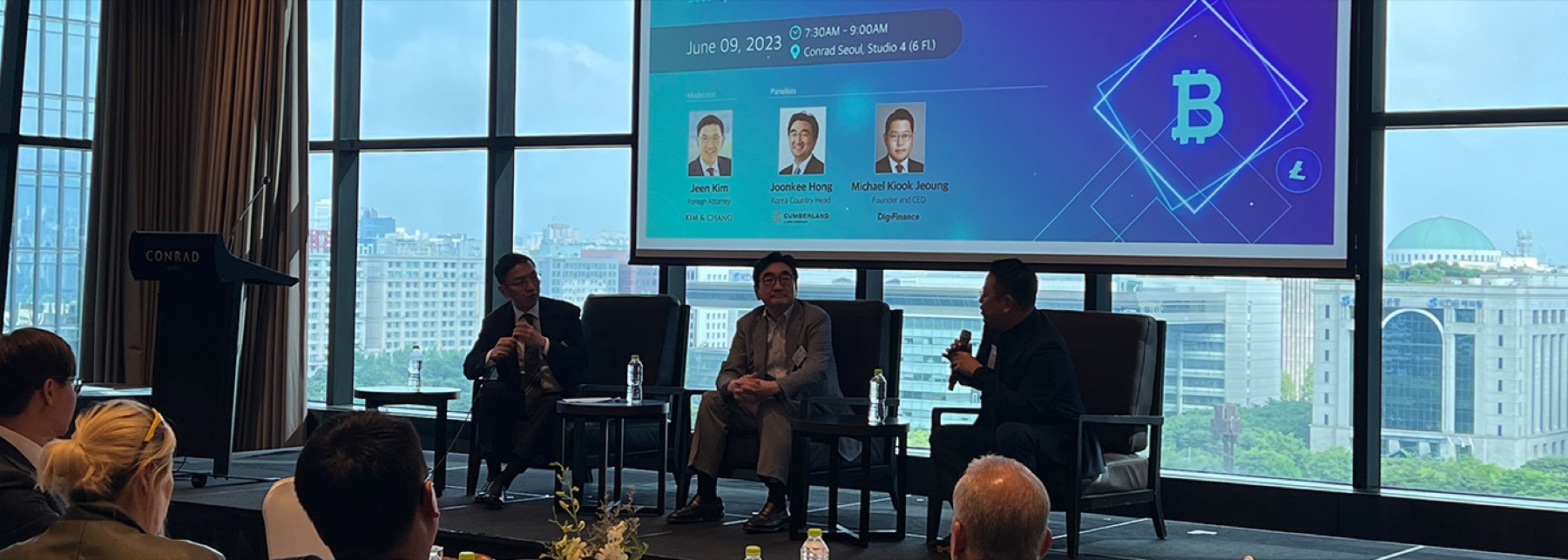 A panel at an AMCHAM Korea committee meeting, with Seoul through the windows behind